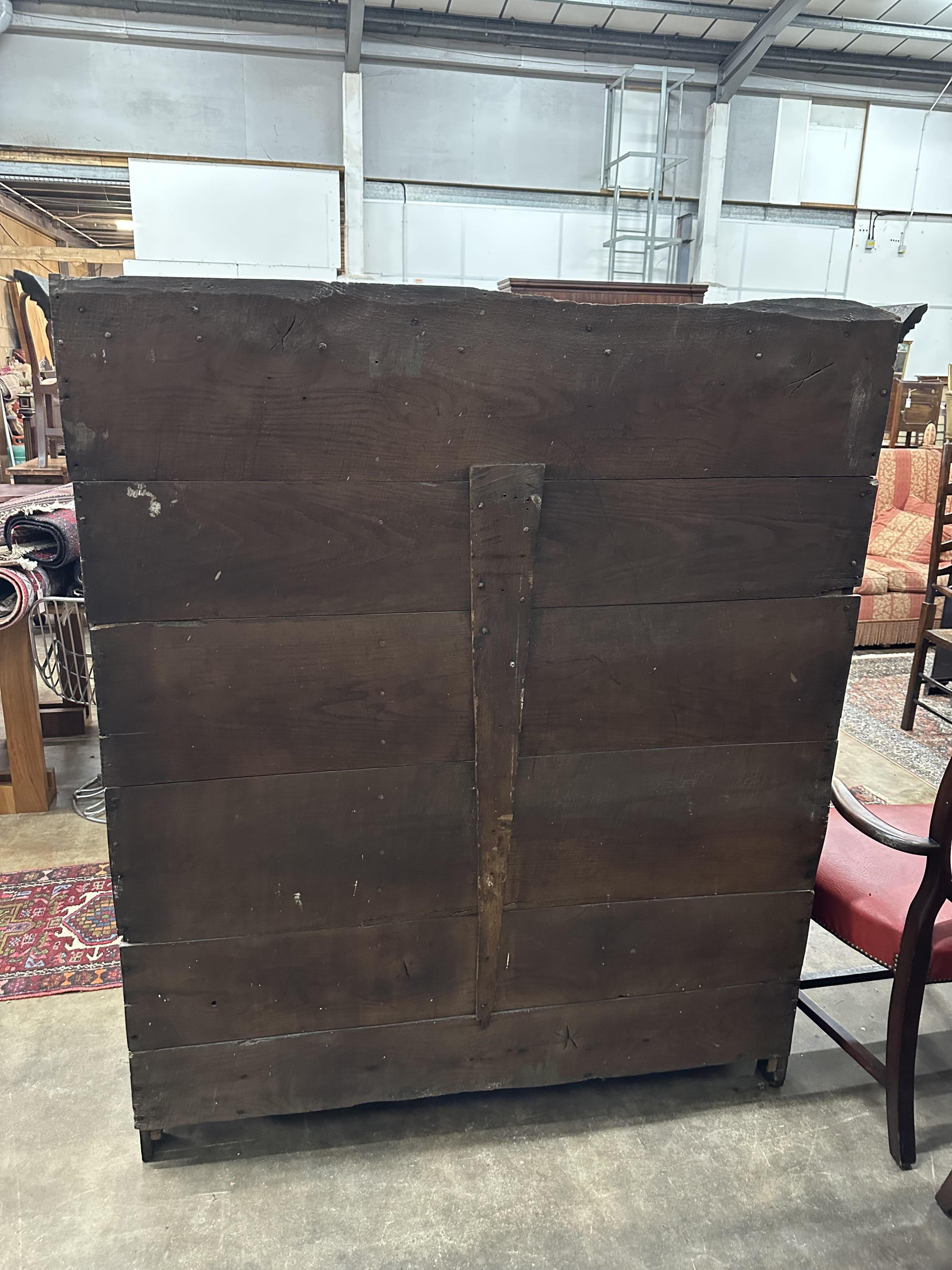 An 18th century and later panelled oak cupboard, width 140cm, height 159cm. Condition - good